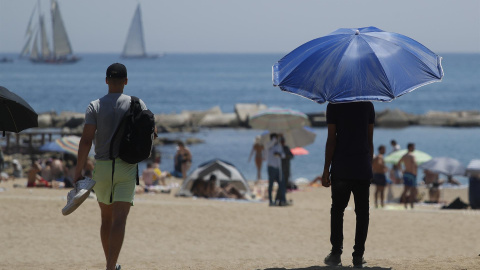 15/07/2022-Dos personas pasean por la Barceloneta el viernes 15 de julio, en Barcelona