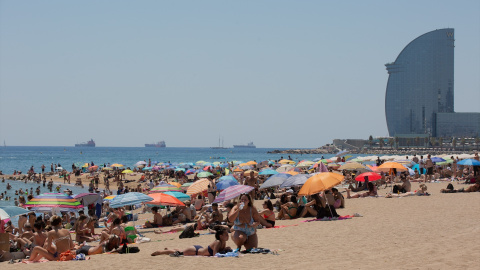 La gente se refugia del calor en la playa de La Barceloneta en Catalunya. Imagen de Archivo.