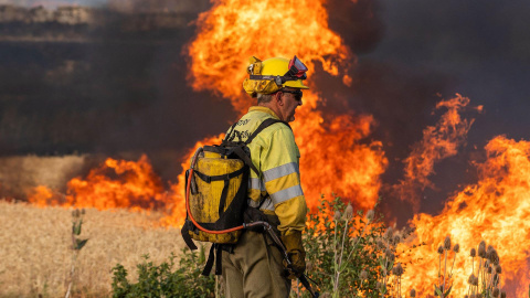 Un bombero observa las llamas del incendio declarado este domingo por la tarde en el término municipal de Quintanilla del Coco, en Burgos, que ha obligado a evacuar a media docena de municipios, entre ellos Santo Domingo Silos y a los monjes del monaster