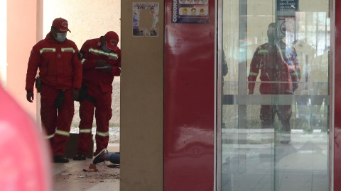 Varios bomberos inspeccionan el lugar del accidente el que murieron varios estudiantes de la Universidad de El Alto (Bolivia).