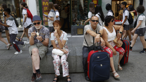 Varios turistas descansan en un banco de granito en el centro de Madrid. EFE/ Mariscal