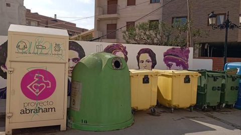 Imagen del muro feminista en Archena (Murcia) oculto tras los contenedores.