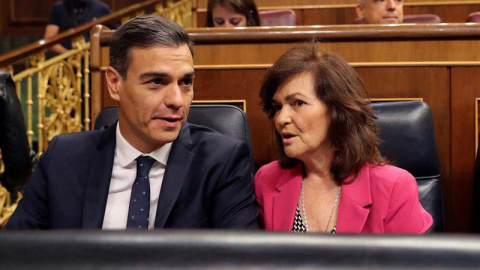 El presidente del gobierno Pedro Sánchez, conversa con la vicepresidenta del gobierno Carmen Calvo en el Congreso de los Diputados. (BALLESTEROS | EFE)