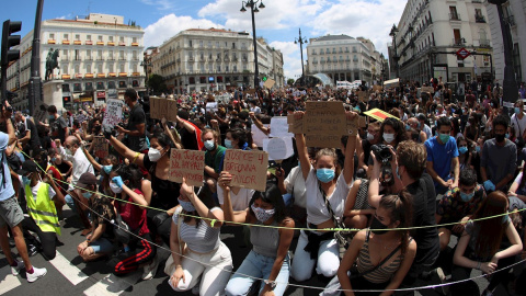 Manifestantes en la Puerta del Sol durante la concentración convocada en Madrid por la Comunidad negra africana y afrodescendiente en España (CNAAE) contra el racismo, tras la muerte del ciudadano afroamericano, George Floyd, durante su detención por l