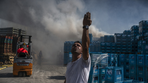 Un hombre se lamenta tas el incendio forestal que permanece activo en Verín (Ourense), y que ha afectado a la empresa de aguas Sousas.