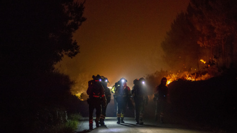 Varios bomberos forestales trabajan en la extinción del incendio de Cures, en Boiro, A Coruña, en la madrugada de este sábado.