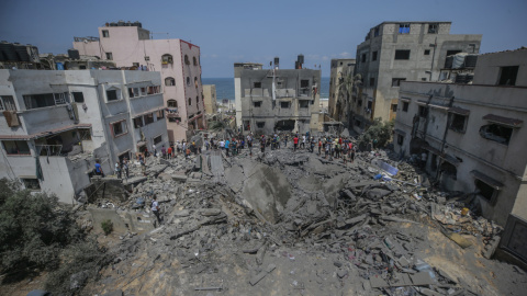 palestinos inspeccionan una casa destruida que pertenece a la familia Shamlakh tras los ataques aéreos israelíes en el sur de la ciudad de Gaza.