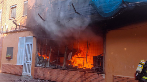 Les flames en l'incendi d'un local a Sant Adrià de Besòs que ha deixat 13 persones ferides per inhalació de fum.