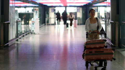 Una pasajera traslada su equipaje en un carrito en la Terminal 5 del aeropuerto londinense de Heathrow . REUTERS/Hannah McKay