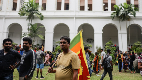 Un hombre sostiene la bandera de Sri Lanka durante la multitudinaria protesta.