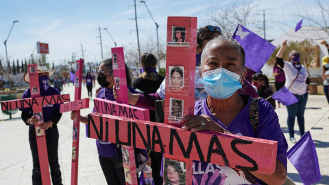 Mujeres sostienen cruces en la que se lee: "Ni una más" en Ciudad Juarez, México