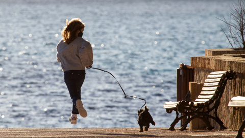 Imagen recurso de una niña paseando a su perro en la localidad mallorquina de Andratx. - EFE