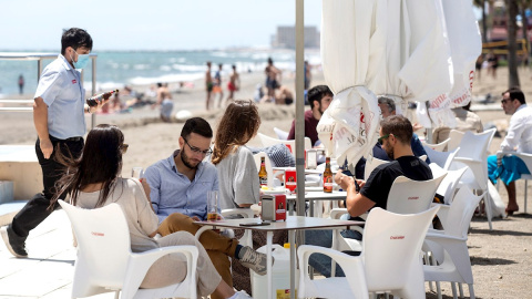 Varias personas disfrutan del buen tiempo en los chiringuitos de la playa de La Misericordia de Málaga el pasado sábado 1 de mayo.