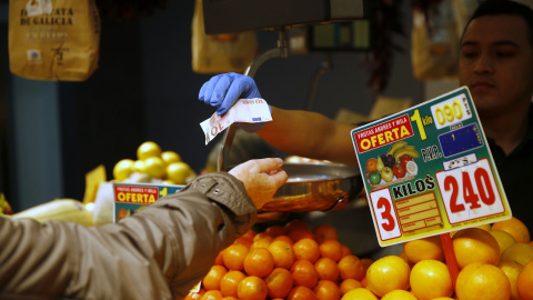 Una mujer compra fruta en un mercado de Madrid. REUTERS