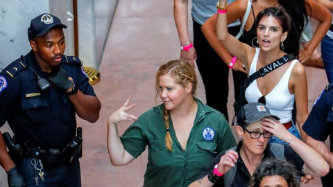 La actriz Amy Schumer y la modelo Emily Ratajkowski gesticulan después de ser detenidas junto con cientos de otros manifestantes. - EFE