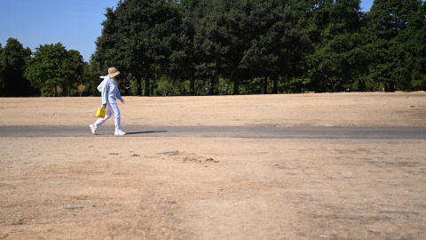 Una mujer camina por un Hyde Park reseco en Londres, Gran Bretaña, el 10 de agosto de 2022. Es probable que Gran Bretaña sufra condiciones de sequía hasta octubre a medida que continúa el clima seco. La Oficina Meteorológica del Reino Unido ha anunci