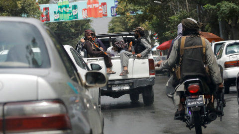 Combatientes talibanes llevan a un hombre detenido en un automóvil militar en Kabul, Afganistán, el 2 de agosto de 2022.