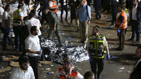 Los servicios médicos atienden a heridos, con los cuerpos de los fallecidos tapados en el suelo, tras la tragedia ocurrida durante la festividad del Lag Baomer, en el norte de Israel.