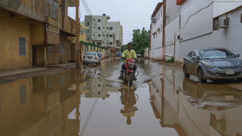 Un hombre tratar de pasar por una calle inundada en Jartum, a 13 de agosto de 2022.