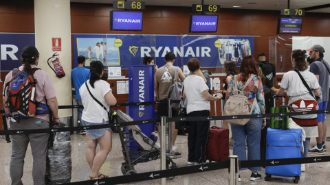 15/08/2022.- Varios pasajeros hacen cola ante uno de los mostradores de facturación en la Terminal 2 del Aeropuerto de Barcelona-El Prat este lunes.