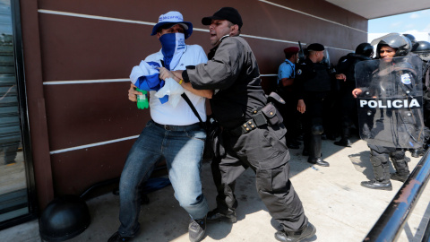 Un policía nicaragüense empuja a un manifestante de la manifestación denominada "Unidos por la libertad" contra el presidente Daniel Ortega que tuvo lugar en Managua esta misma semana. | Oswaldo Rivas / Reuters