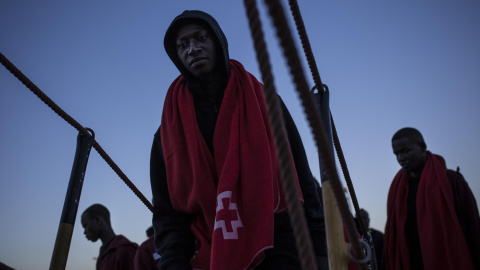 Un joven migrante sube a borde de un barco de Sasemar junto a otros 200 personas para pasar la noche tras ser rescatado de una patera durante el fin de semana. JAIRO VARGAS