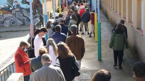 Decenas de personas hacen cola para votar en el Colegio Público La Navata, a 4 de mayo de 2021, en Madrid (España).