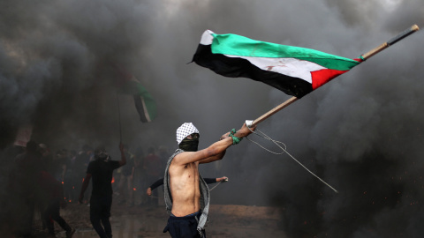 Un manifestante ondea una bandera de Palestina durante las protestas en la frontera con Israel en Gaza del viernes 26 de octubre. Mohammed Salem/REUTERS