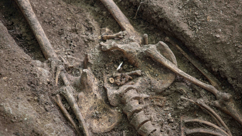 Un botón y una hebilla hallados junto a los huesos de exhumados en el cementerio de Colmenar Viejo.