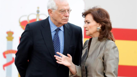 La vicepresidenta del Gobierno, Carmen Calvo y el ministro de Exteriores, Josep Borrell, conversan antes del inicio del desfile militar, uno de los actos conmemorativos del Día de la Fiesta Nacional, que presiden los Reyes junto a sus hijas, la princesa