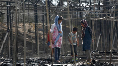 Personas refugiadas en los escombros de su refugio tras una incendio en el campo de refugiados de Moria, en la isla griega de Lesbos.- REUTERS/ARCHIVO