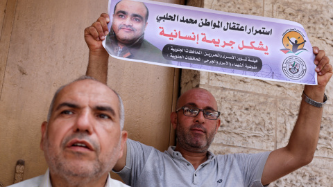 Un hombre sostiene una foto de Mohammad al Halabi, durante una protesta en solidaridad tras la decisión de un tribunal israelí de sentenciarlo a 12 años, en la ciudad de Gaza, el 30 de agosto de 2022.