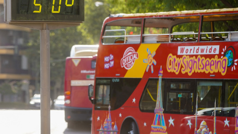 01/08/2022 Un autobús turístico pasa sin pasajeros delante de un termómetro que marca 5Oº en otro día con altas temperaturas en la capital andaluza a 25 de julio del 2022 en Sevilla