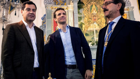 El presidente del PP, Pablo Casado (c), acompañado del presidente del PP-A, Juanma Moreno (i), y del presidente de la Hermandad del Rocío de Huelva, Antonio Sánchez de Piña. /EFE