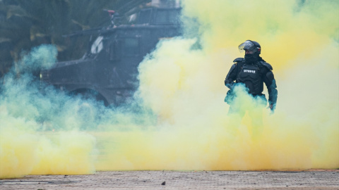 28/04/2022-Un agente de la policía antidisturbios se para entre el humo durante una protesta contra el gobierno del presidente Iván Duque el 28 de abril de 2022