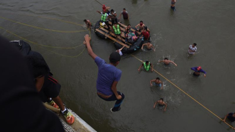 Migrantes hondureños que se encuentran en la frontera de México y Guatemala, se lanzan del puente hacia el río Suchiate para cruzar hacia México. EFE/EDWIN BERCÍAN