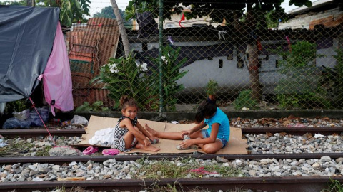 Niñas juegan en la frontera entre Tecún Umán (Guatemala) y México. EFE/ESTEBAN BIBA