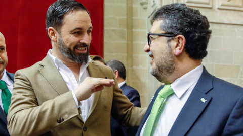 El líder nacional de Vox, Santiago Abascal, y el diputado de esa formación, el juez Francisco Serrano, conversando al inicio de la segunda jornada del debate de investidura del presidente del PP andaluz, Juanma Moreno, en el Parlamento andaluz en Sevill