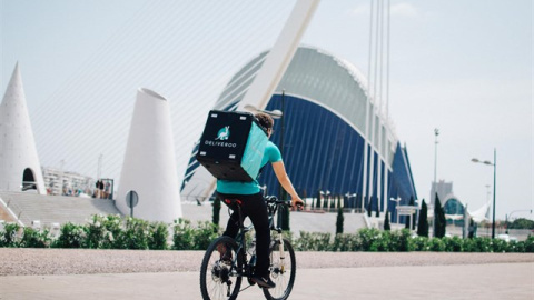 Un repartidor de Deliveroo, junto a la Ciudad de las Artes y las Ciencias de Valencia. E.P.