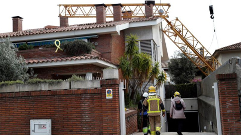 10/02/2019.- Bomberos en las inmediaciones del lugar en el que un operario ha fallecido y otro ha resultado herido menos grave al caer este domingo una grúa de construcción sobre un edificio en Sant Just Desvern (Barcelona). EFE/Toni Albir