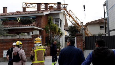 10/02/2019.- Bomberos en las inmediaciones del lugar en el que un operario ha fallecido y otro ha resultado herido menos grave al caer este domingo una grúa de construcción sobre un edificio en Sant Just Desvern (Barcelona). EFE/Toni Albir