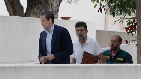 El expresidente de la Generalitat Valenciana y exministro de Trabajo, Eduardo Zaplana, a su llegada a su chalé de Benidorm (Alicante) acompañado por agentes de la UCO de la Guardia Civil. - EFE