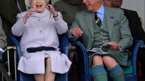 Fotografía de septiembre de2012, de la reina Isabel II y el príncipe Carlos, animando a los participantes en una carrera de sacos en los tradicionales juegos de Braemar Gathering, enEscocia. REUTERS/Russell Cheyne