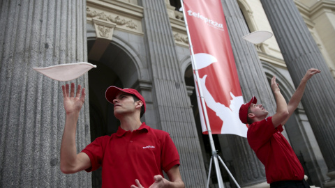 Los trabajadores de Telepizza lanzan la masa al aire en una demostración en la Bolsa de Madrid el primer día de cotización de la empresa.. REUTERS/Andrea Comas