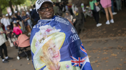 Una mujer afrodescendiente se envuelve con una enseña de Isabel II.