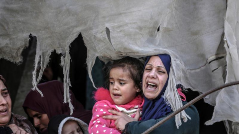 12/11/2018.- La hija (C) y hermana (dcha) de Khaled Quider, de las Brigadas Salahedin, lloran durante su funeral en la localidad de Jan Yunis, en el sur de la franja de Gaza, hoy, 12 de noviembre de 2018. Miles de personas asistieron hoy a los funerales e