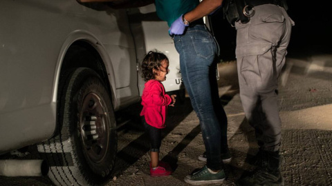 La niña Yana, de Honduras, llora mientras su madre, Sandra Sánchez, es cacheada por un policía estadounidense en la frontera en Texas./ JOHN MOORE (GETTY IMAGES)