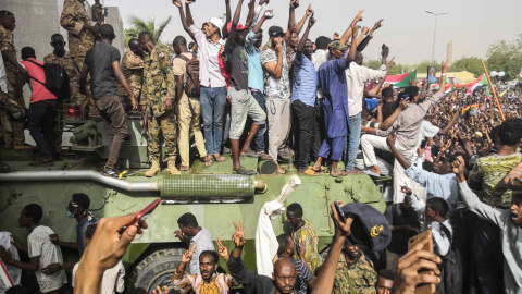 11/04/2019 - Los manifestantes sudaneses en pie sobre un vehículo militar blindado del ejército, tras el anuncio de renuncia de al-Bashir, 11 de abril de 2019 | AFP