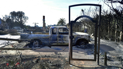 El marco de hierro de una entrada es todo lo que queda en pie de una casa incendiada en Filaree Heights Road, Malibu.- AFP