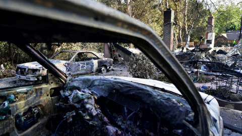 Vehículos calcinados yacen en mitad de la carretera en las inmediaciones de Filaree Heights Road, Malibu.- AFP